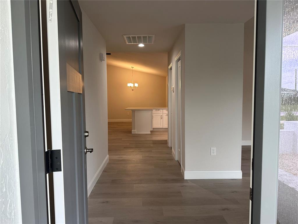A view through an open front door into a hallway with light wood-look flooring — 373 DORCHESTER STREET, PORT CHARLOTTE, FL