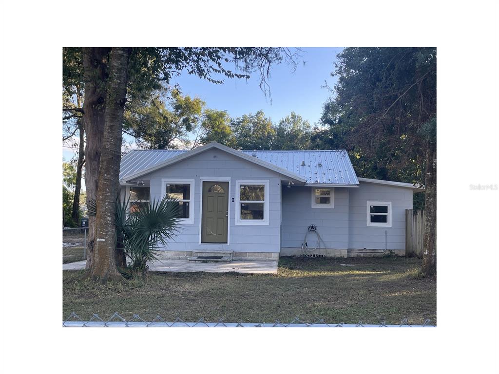 A light blue, single-story house with a metal roof and a small concrete front patio — 6220 SE 118TH PLACE, BELLEVIEW, FL