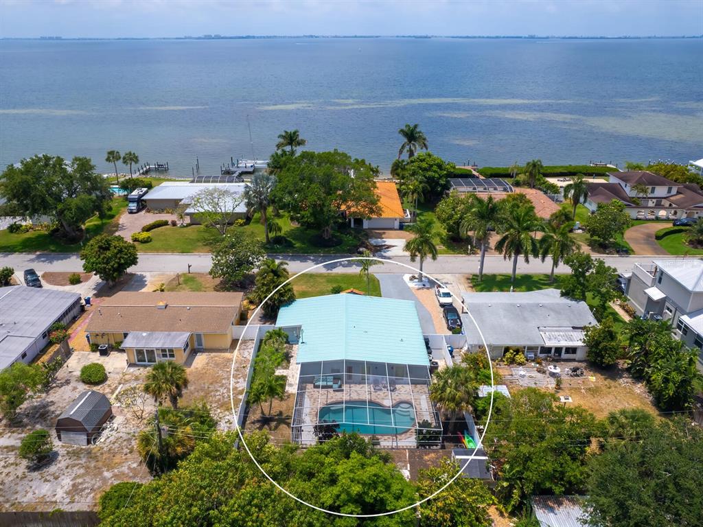 An aerial view shows a house with a light blue roof and a screened-in pool — 3115 BAY DRIVE, BRADENTON, FL