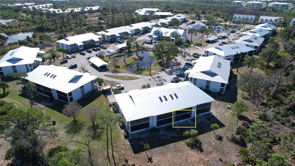 An aerial view shows a multi-story residential building with a highlighted ground-floor patio area — 6800 PLACIDA ROAD UNIT 163, ENGLEWOOD, FL