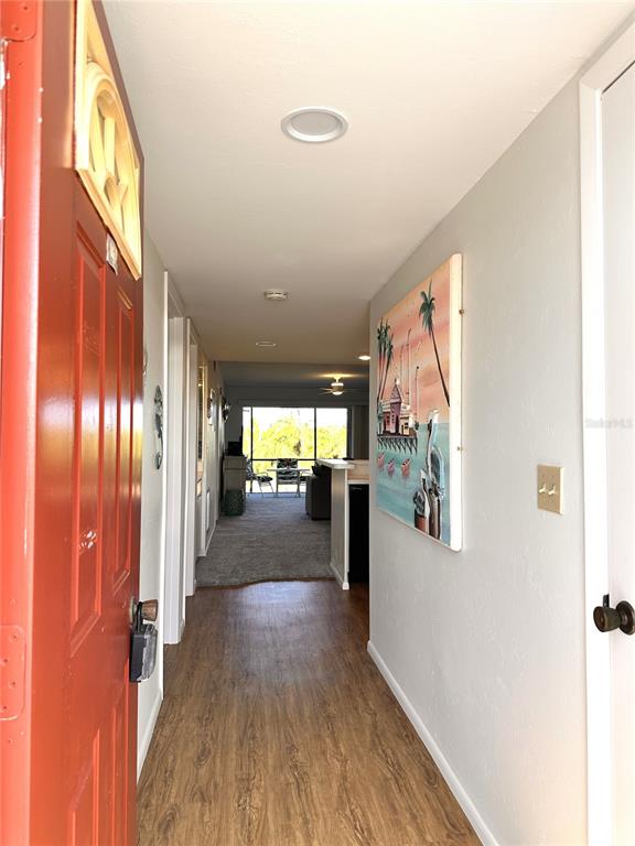 A view from an open front door looking down a hallway toward a living area — 6800 PLACIDA ROAD UNIT 163, ENGLEWOOD, FL