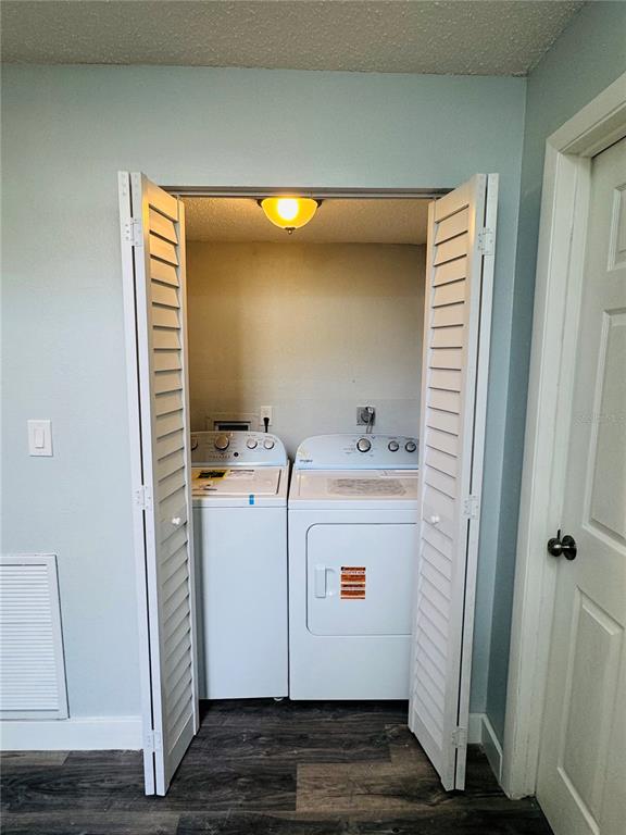 A laundry closet with a washer and dryer sits between white louvered doors — 4100 PLAYER CIRCLE UNIT 101, ORLANDO, FL