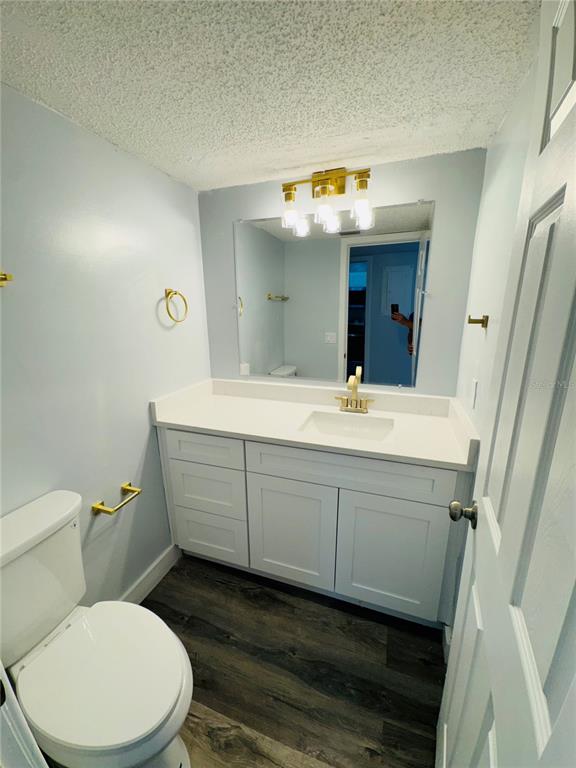 A bathroom features a white vanity with gold hardware, a mirror, and a toilet — 4100 PLAYER CIRCLE UNIT 101, ORLANDO, FL