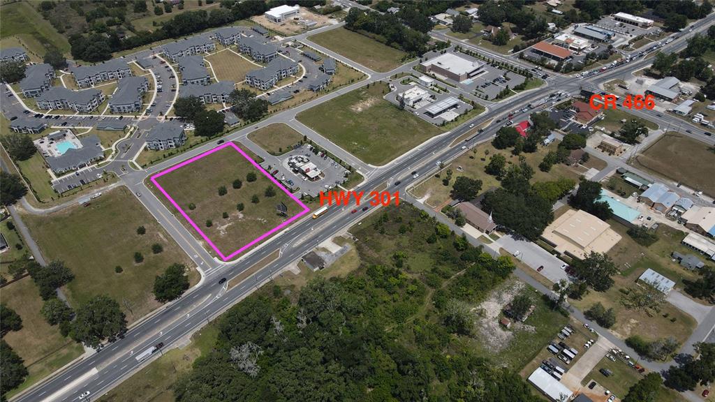 An aerial view shows a vacant rectangular lot outlined in pink adjacent to a highway — 11532 N US HIGHWAY 301, OXFORD, FL