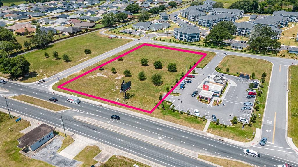 An aerial view shows a vacant rectangular lot outlined in pink next to a restaurant — 11532 N US HIGHWAY 301, OXFORD, FL
