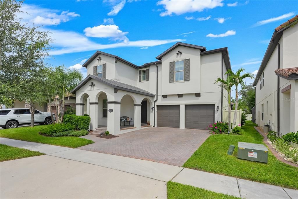A two-story house with a stucco exterior, arched front porch, and a two-car garage — 8254 PROCIDA ISLE LANE, WINDERMERE, FL