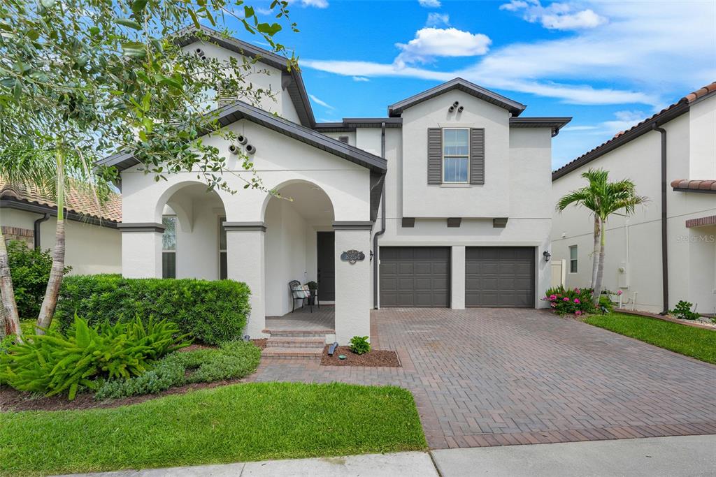 A two-story house with a white stucco exterior, arched entryway, and a two-car garage — 8254 PROCIDA ISLE LANE, WINDERMERE, FL