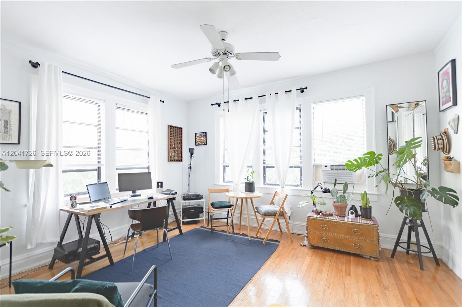 A bright home office features hardwood floors, a ceiling fan, and a large desk area — 320 Mendoza Ave # 3, Miami FL 33134, MIAMI, FL