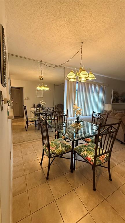 A dining area features a glass-topped table, floral-patterned chairs, and a large mirrored wall — 3668 TROPHY BOULEVARD, NEW PORT RICHEY, FL