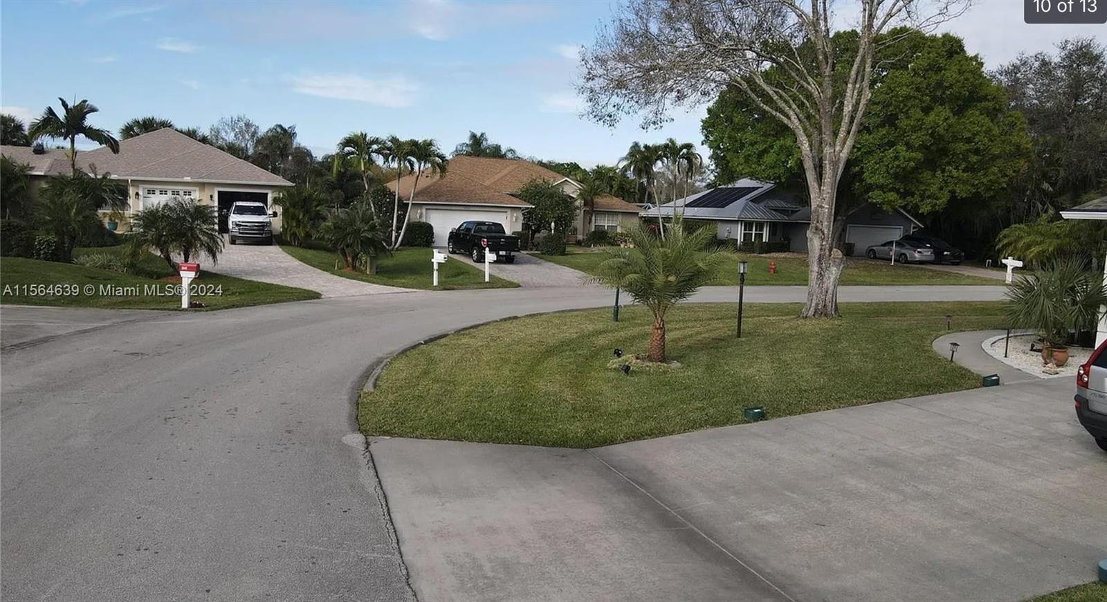 A suburban street view showing houses with driveways, palm trees, and manicured lawns — 755 38th Court, Vero Beach FL 32968, VERO BEACH, FL