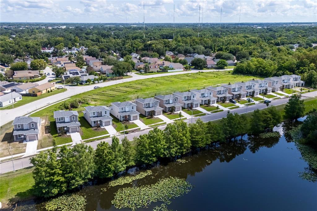 An aerial view shows a row of suburban houses bordering a pond and green space — 5383 VISTA LAGO DRIVE, ORLANDO, FL