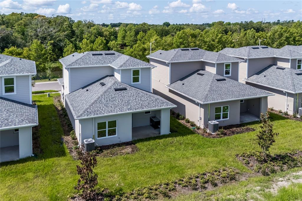 An aerial view shows the back exteriors of several modern two-story houses with gray roofs — 5383 VISTA LAGO DRIVE, ORLANDO, FL