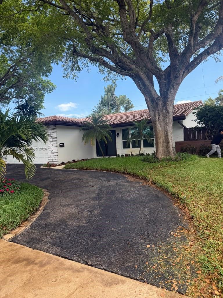 A single-story white house with a tile roof and a large tree in the yard — 5300 Adams St, Hollywood FL 33021, HOLLYWOOD, FL