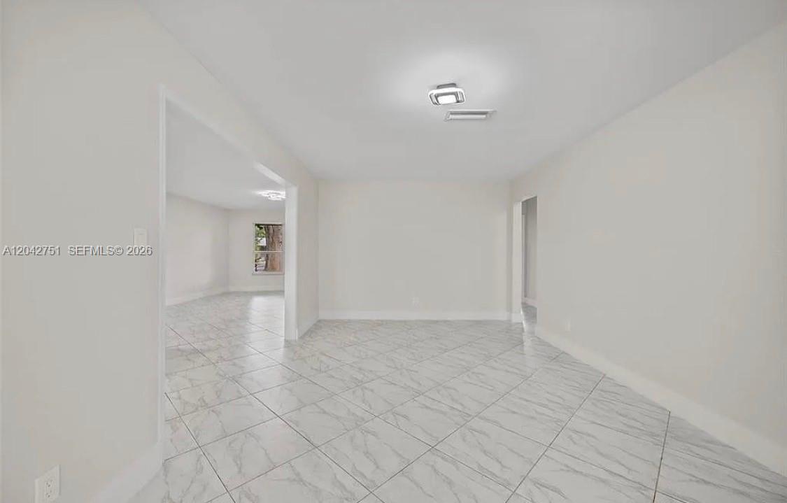An interior view of a room with white walls and light-colored marble-patterned tile flooring — 5300 Adams St, Hollywood FL 33021, HOLLYWOOD, FL