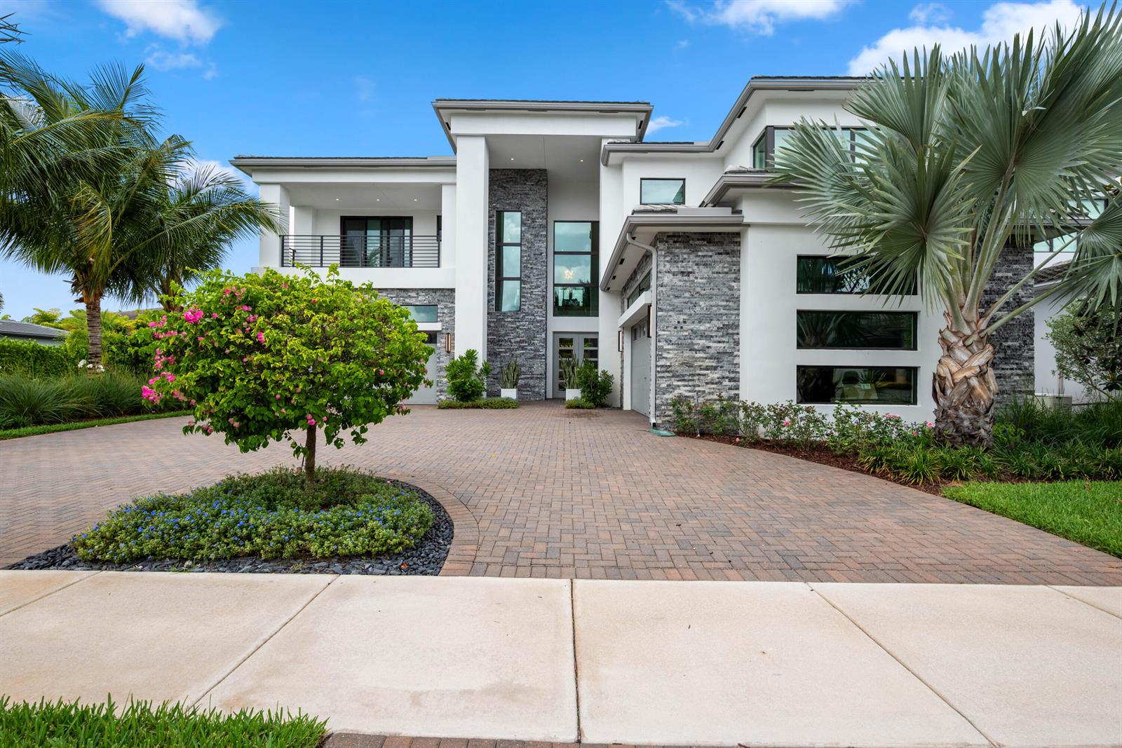 A modern two-story house features a stone facade, white stucco, and a paved driveway — 9593 Vescovato Way, Boca Raton FL 33323, BOCA RATON, FL