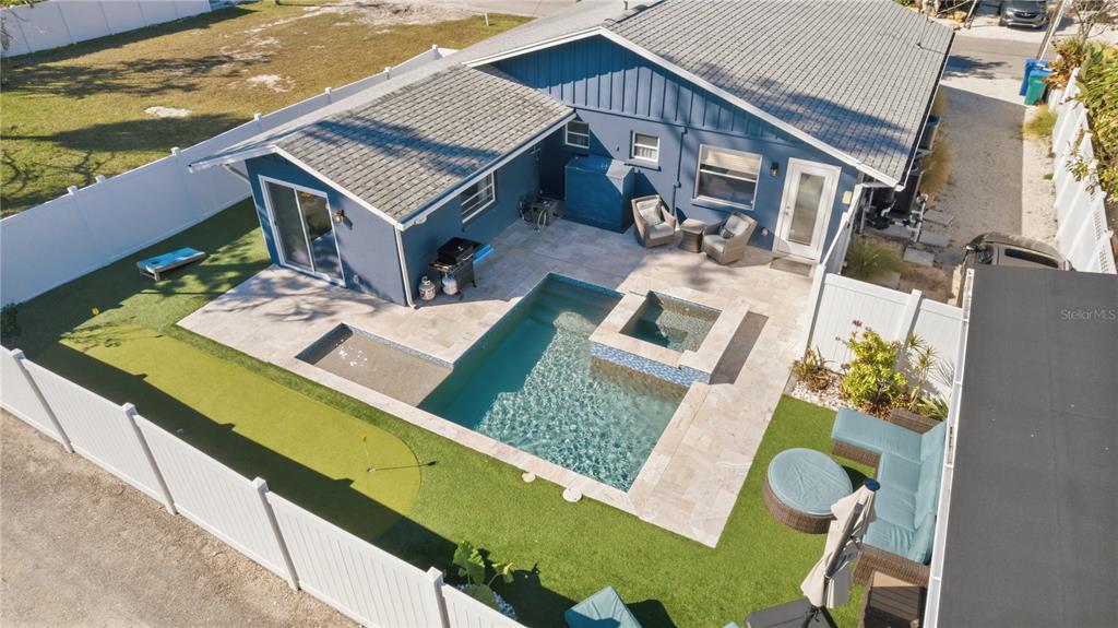 An aerial view shows a blue house with a backyard pool, spa, and putting green — 205 HAVERKOS COURT, HOLMES BEACH, FL
