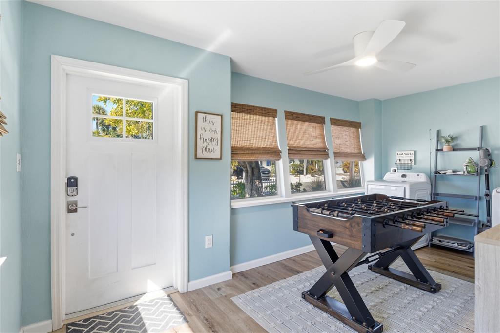 A light blue room features a foosball table, a white front door, and laundry appliances — 205 HAVERKOS COURT, HOLMES BEACH, FL