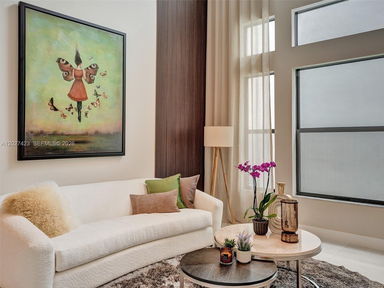 A living room features a white sofa, round coffee tables, and a large butterfly-themed painting — 8642 Swinley Forest Way, Boca Raton FL 33434, BOCA RATON, FL