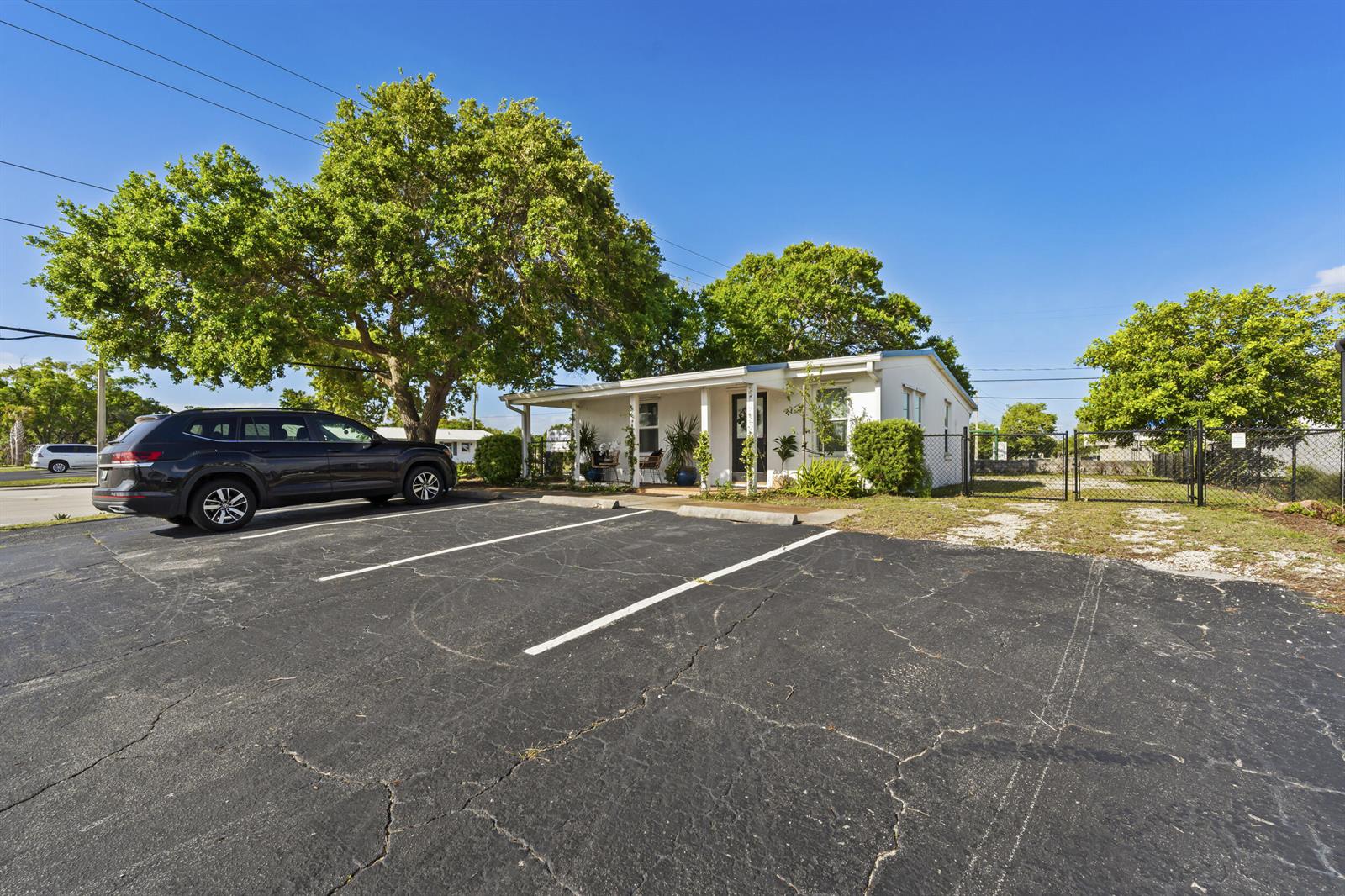 A single-story white building with a covered porch sits behind a paved parking lot — 1324 16th Street, Vero Beach FL 32960, VERO BEACH, FL