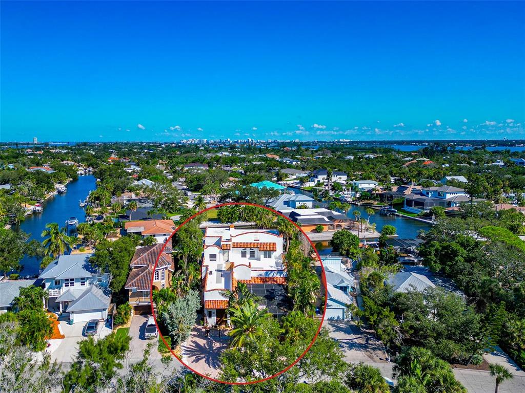 An aerial view shows a white house with a red tile roof surrounded by trees — 681 AVENIDA DE MAYO, SARASOTA, FL