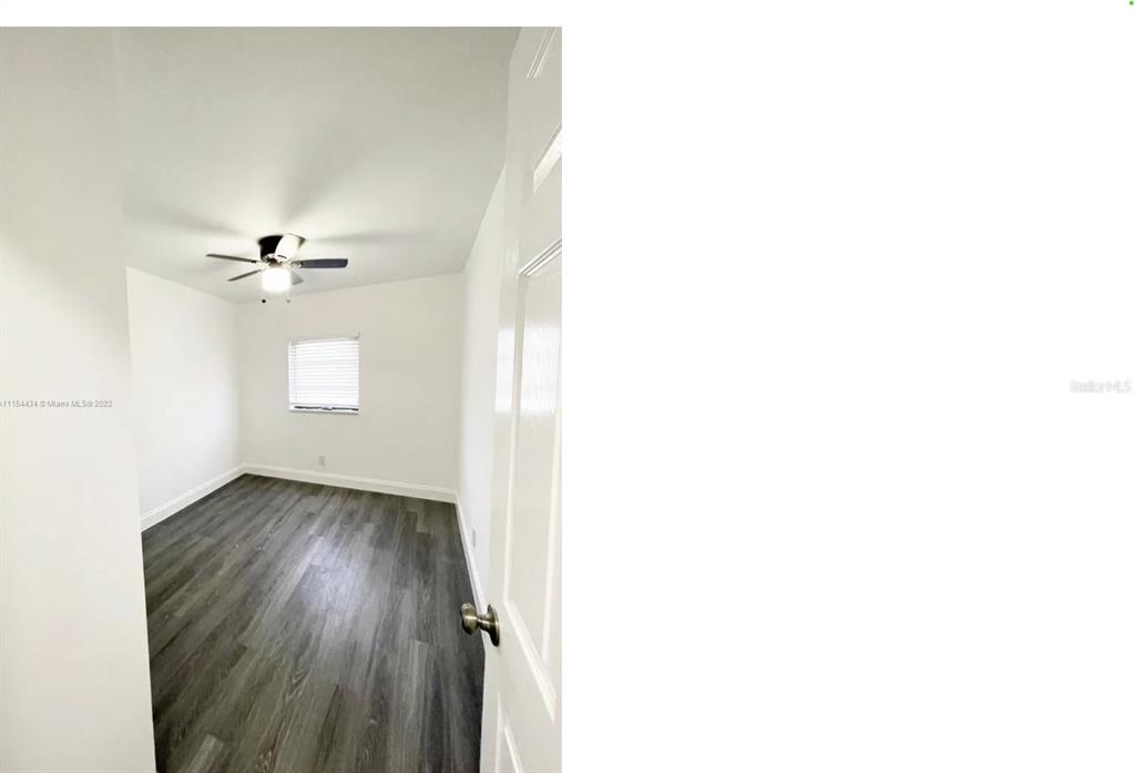 An empty bedroom features white walls, a ceiling fan, and dark wood-look flooring — 710 SW 9TH STREET, DELRAY BEACH, FL