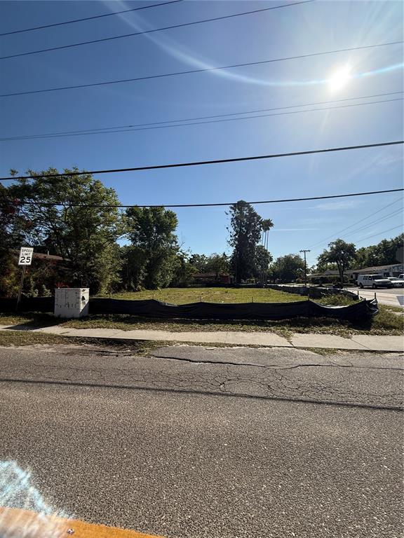 A vacant, fenced-in residential lot sits beside a paved road under a bright sun — 4801 N 30TH STREET, TAMPA, FL