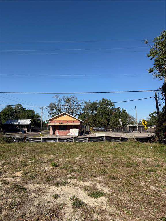 A vacant, grassy lot sits in front of a small, single-story commercial building — 4801 N 30TH STREET, TAMPA, FL