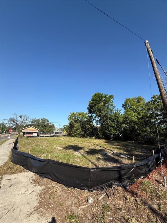 A vacant, fenced-in lot sits under a clear blue sky next to a paved road — 4801 N 30TH STREET, TAMPA, FL