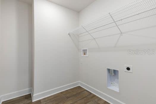 A laundry room with white walls, wood-look flooring, and a wire shelf above hookups — 9 LAMAR LANE, PALM COAST, FL
