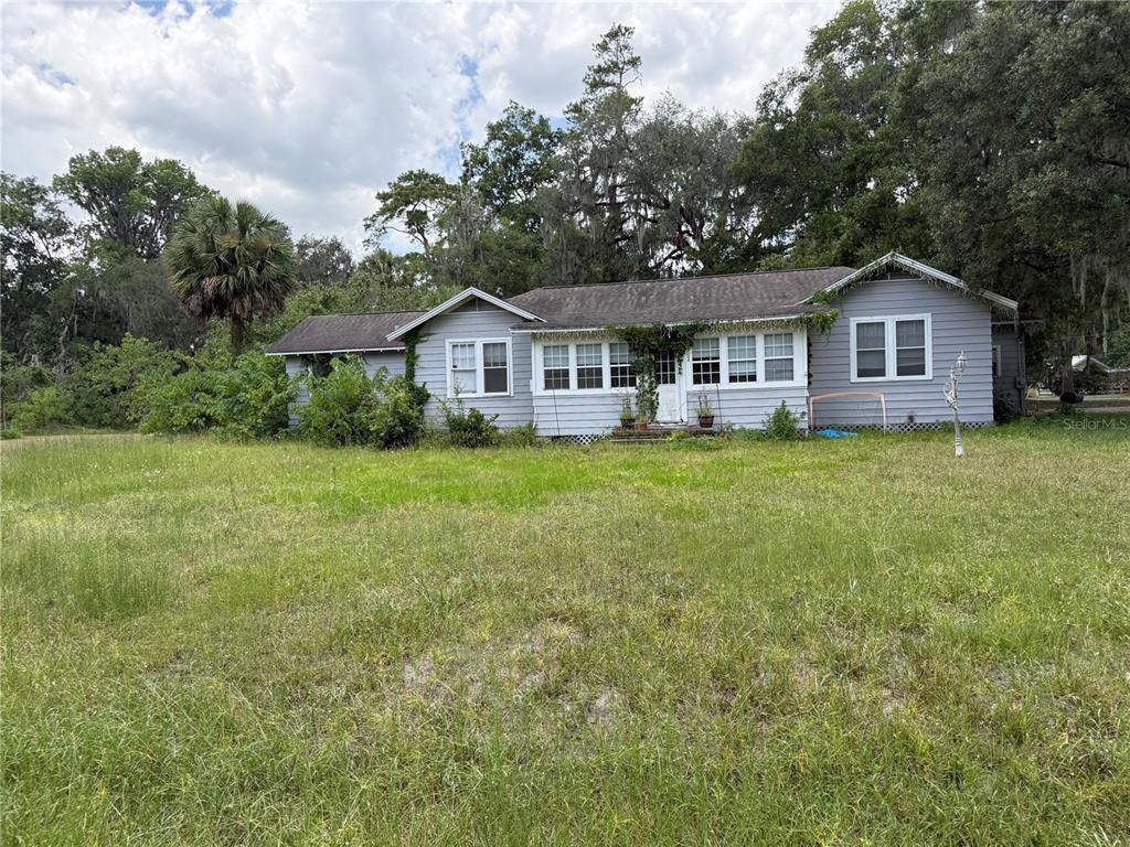 A single-story gray house with a shingled roof sits on a large, grassy lot — 4500 SE 18TH AVENUE, OCALA, FL