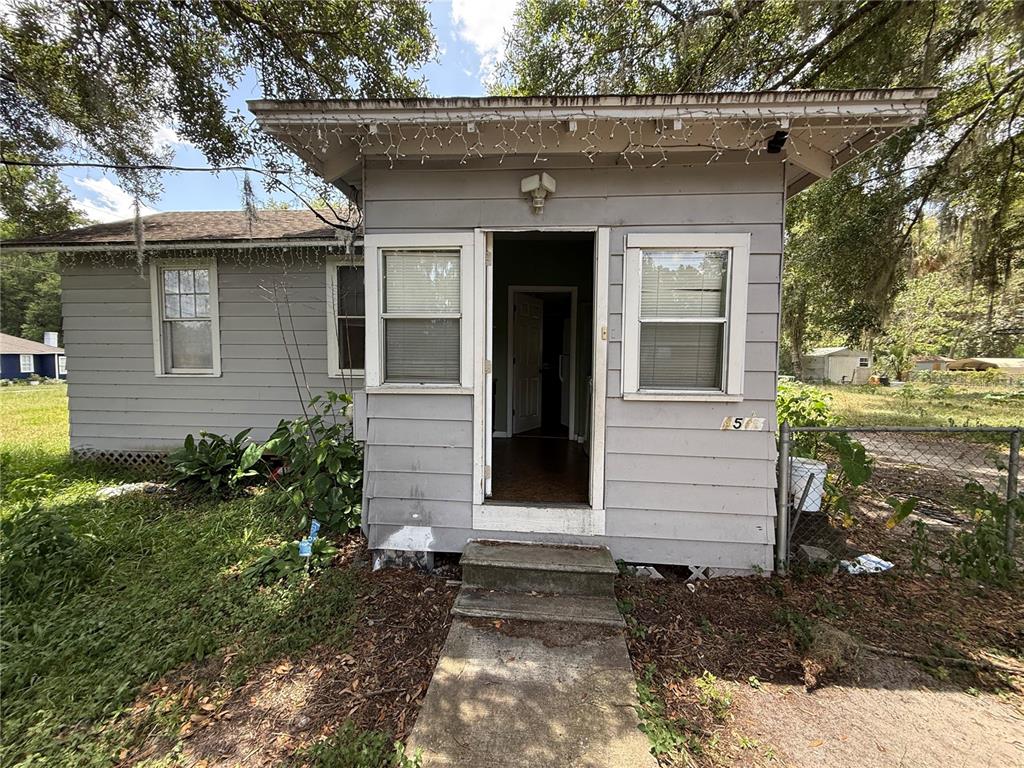 A gray, single-story house with a small front porch and a concrete walkway — 4500 SE 18TH AVENUE, OCALA, FL