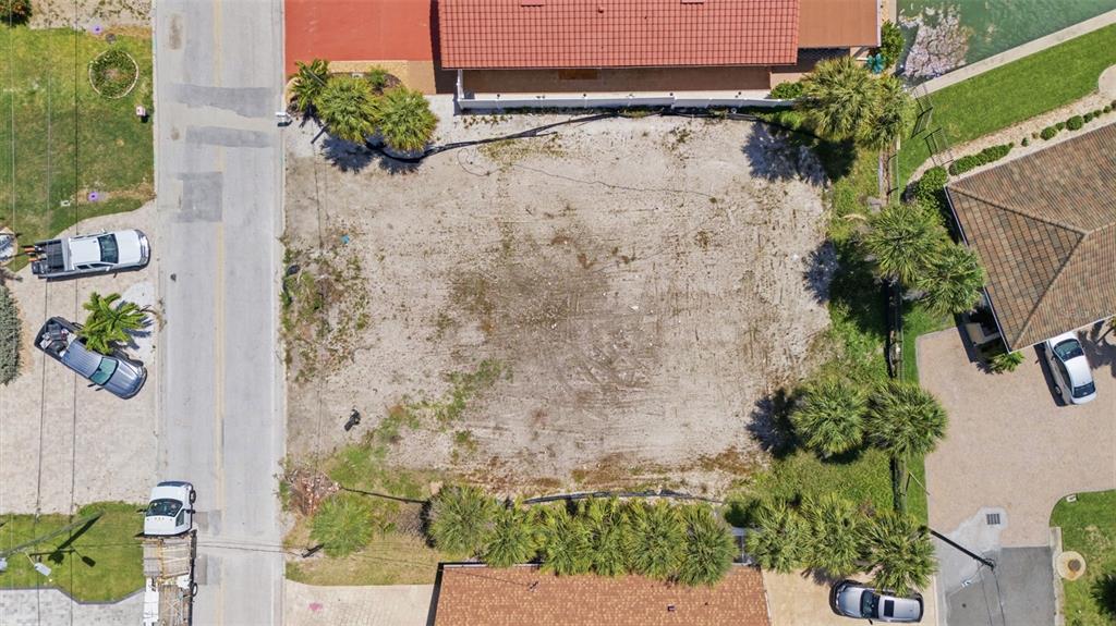 An aerial view shows a vacant, sandy residential lot situated between two existing houses — 620 59TH AVENUE, ST PETE BEACH, FL