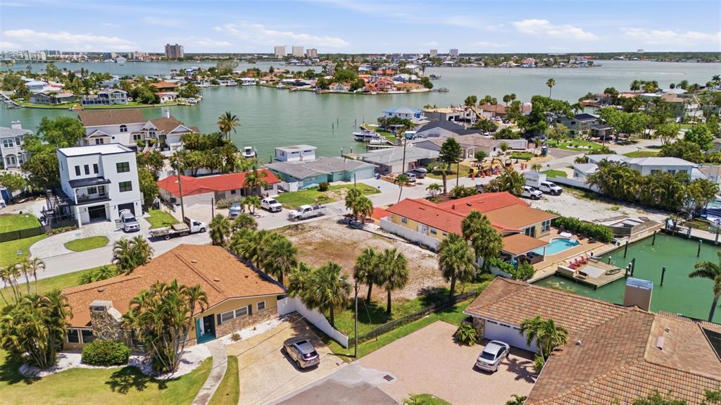 An aerial view shows a vacant residential lot situated between two houses near the water — 620 59TH AVENUE, ST PETE BEACH, FL