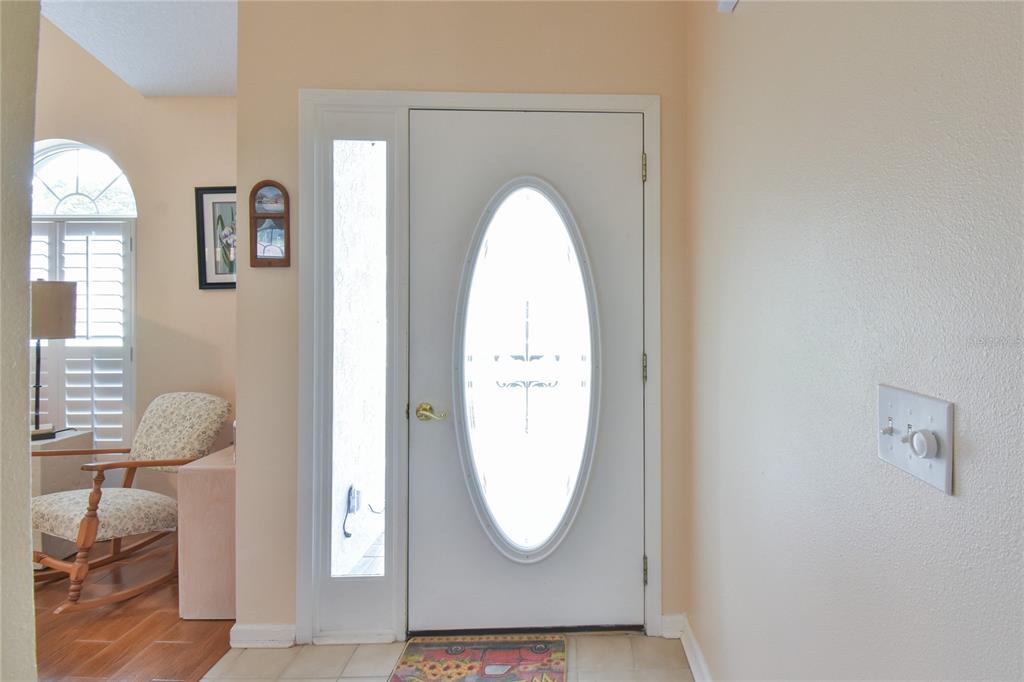 An entryway features a white front door with an oval glass insert and a sidelight — 4993 NW 18TH STREET, OCALA, FL