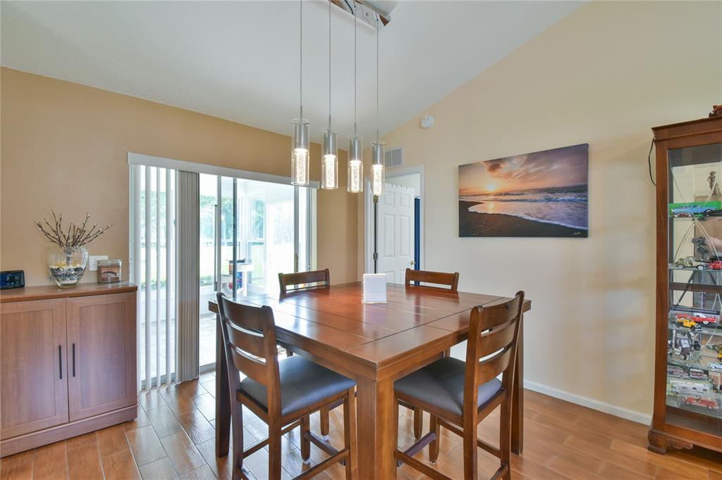 A dining room features a wooden table, four chairs, a pendant light, and a display cabinet — 4993 NW 18TH STREET, OCALA, FL
