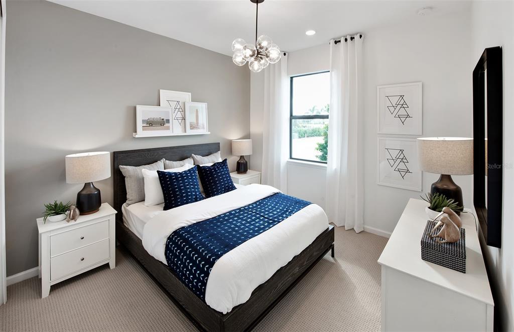 A modern bedroom features a dark wood bed frame, blue accents, and white nightstands — 4739 BLUE STAR COURT, NORTH PORT, FL