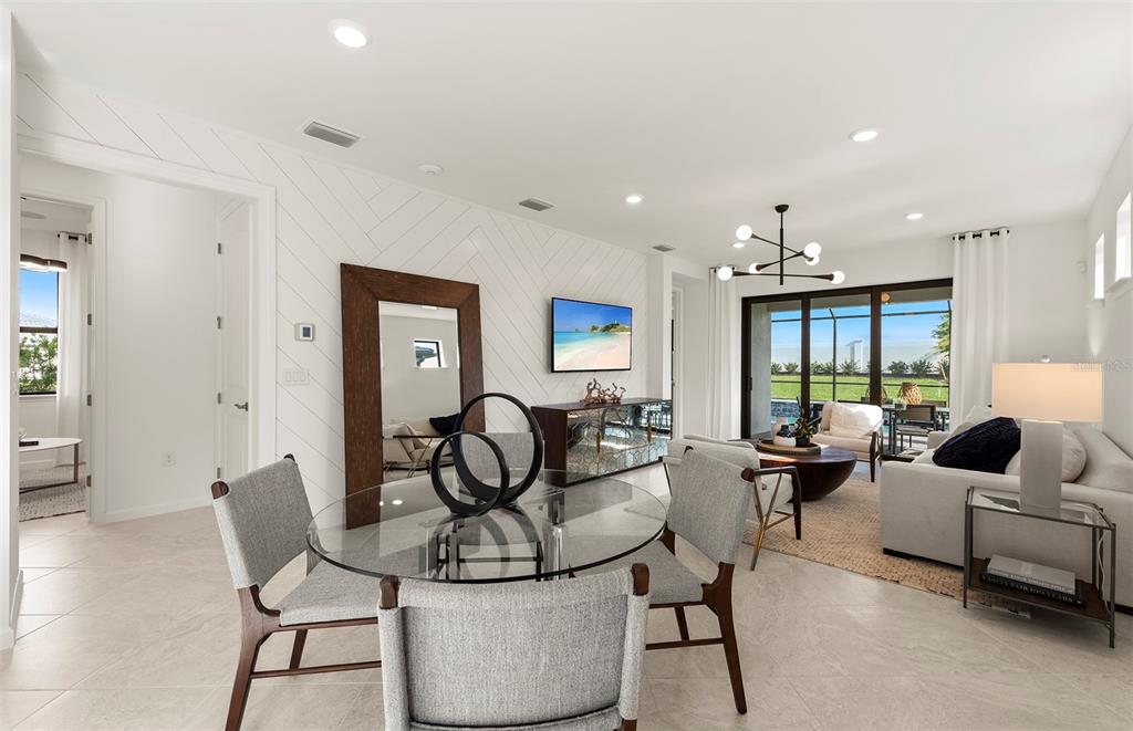 A bright living and dining area features white herringbone walls, a glass table, and sliding doors — 4739 BLUE STAR COURT, NORTH PORT, FL