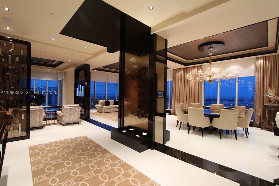 A modern dining room and living area feature a central water feature and marble floors — 900 Brickell Key Blvd, Miami FL 33131, MIAMI, FL