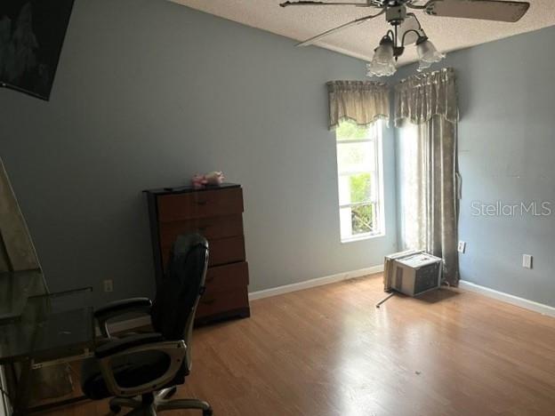 A bedroom with light blue walls, wood-look flooring, a ceiling fan, and a wooden dresser — 26 SAINT KITTS CIRCLE, WINTER HAVEN, FL
