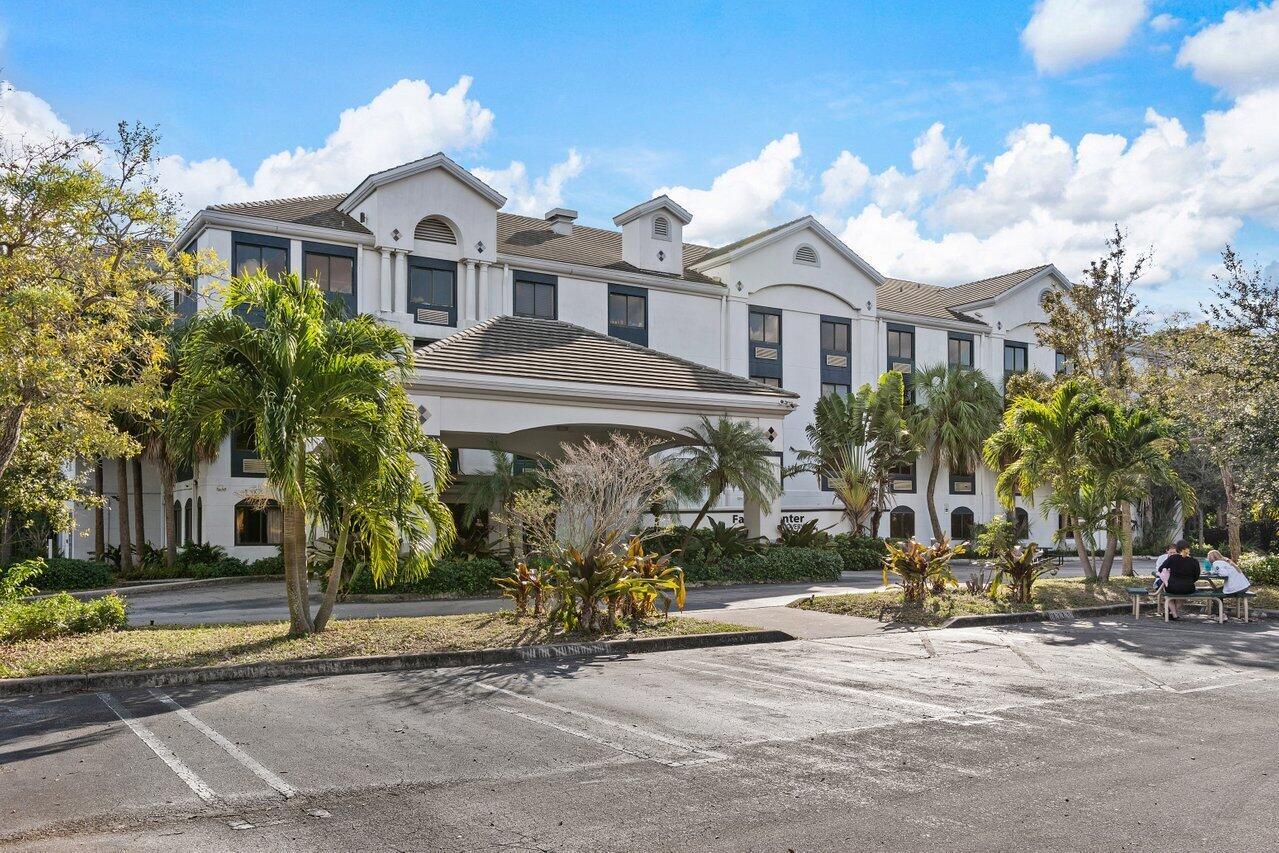 A three-story building with a covered entrance and palm trees in front of a parking lot — 7051 N Seacrest Boulevard, Lantana FL 33462, LANTANA, FL