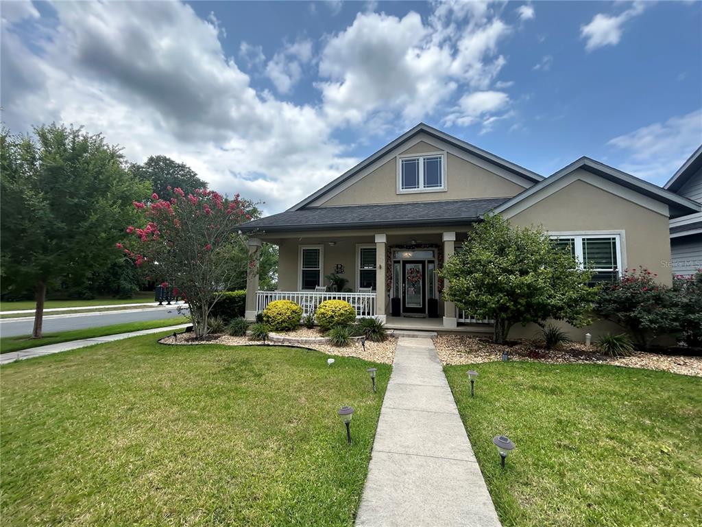 A single-story house with a front porch, tan siding, and a landscaped yard — 11788 SW 30TH AVENUE, GAINESVILLE, FL