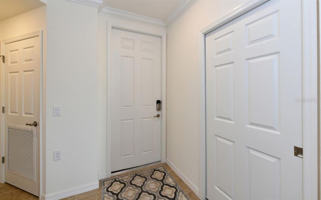 A white interior door and two closet doors are visible in this tiled entryway — 17006 VARDON TERRACE UNIT 208, BRADENTON, FL