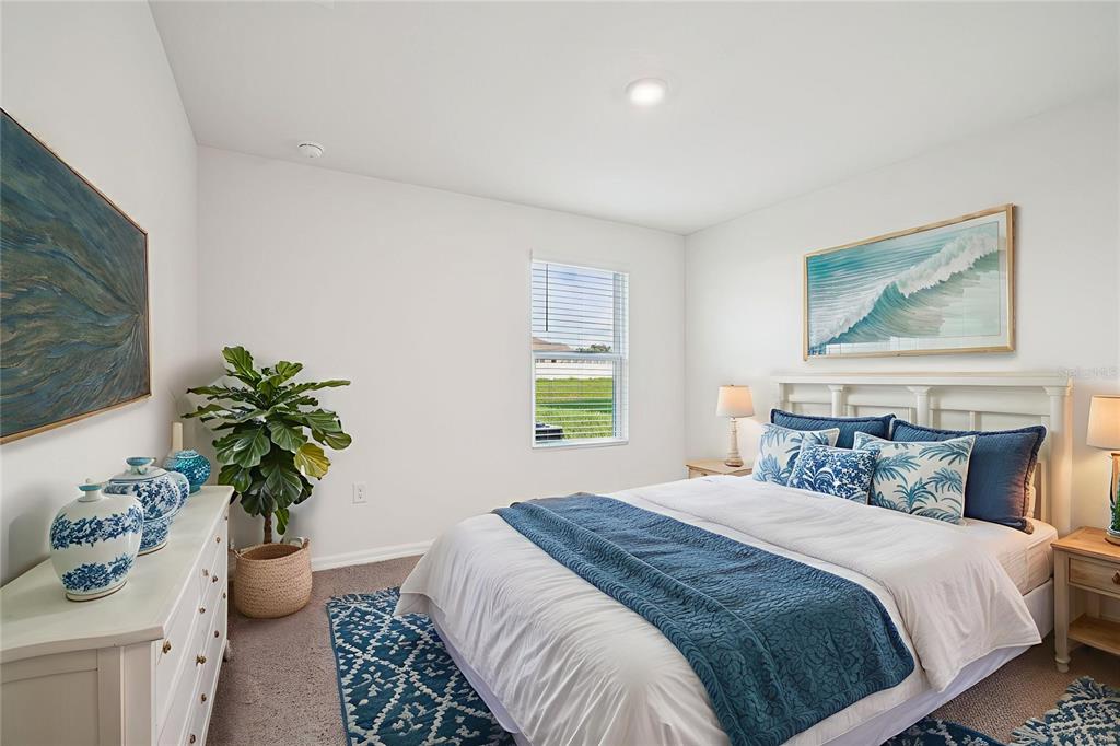 A bedroom features a bed with blue bedding, a white dresser, and a potted plant — 8914 SW 46TH AVENUE, OCALA, FL