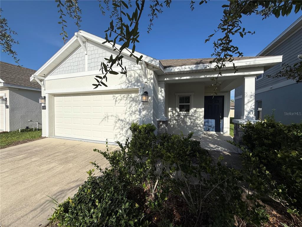 A single-story house features a two-car garage, a covered entryway, and light-colored exterior siding — 558 JETT LANE, DAVENPORT, FL