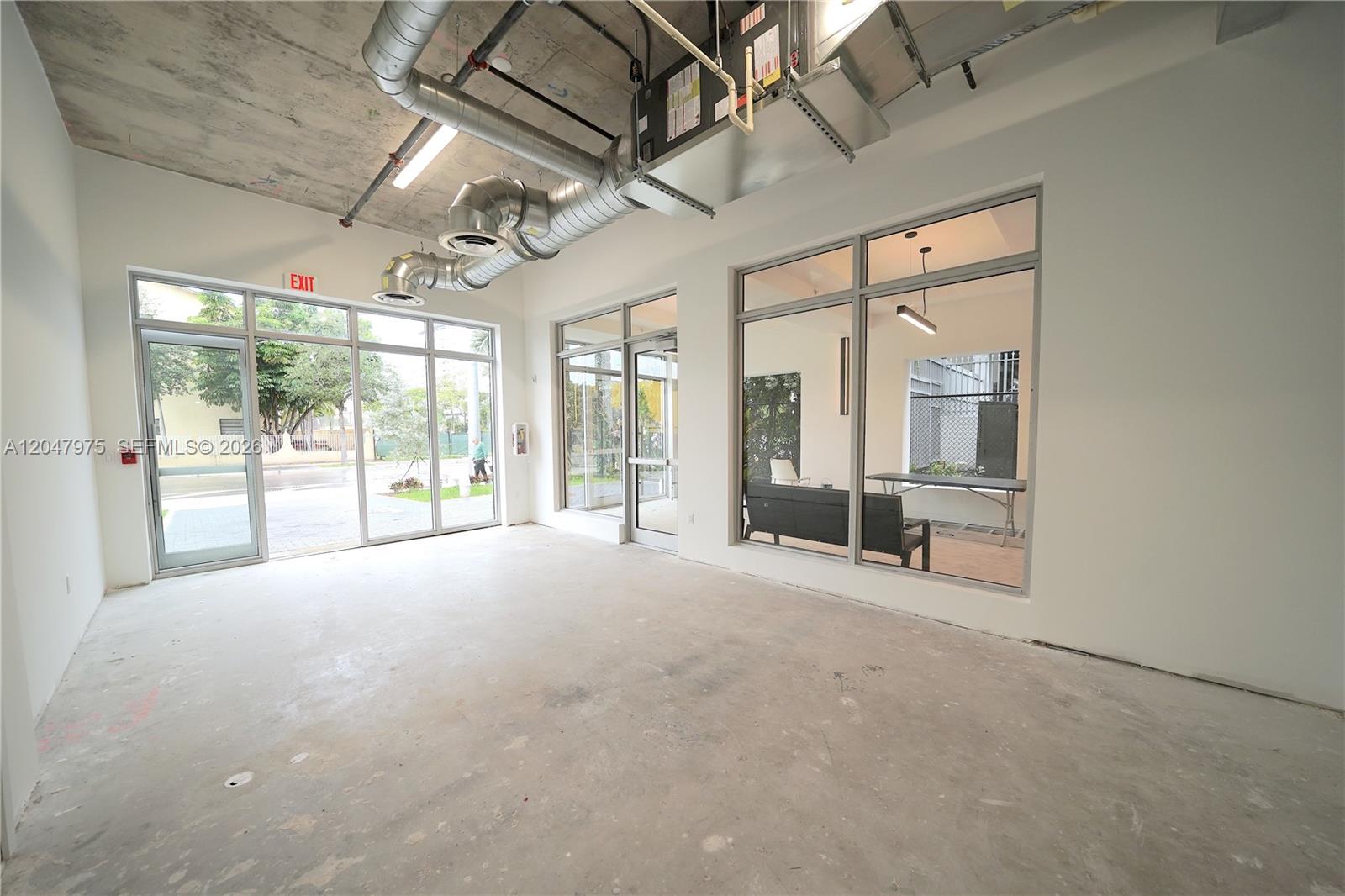 An unfinished commercial space features exposed ductwork, concrete floors, and large glass storefront windows — 650 SW 1st St # 1, Miami FL 33130, MIAMI, FL