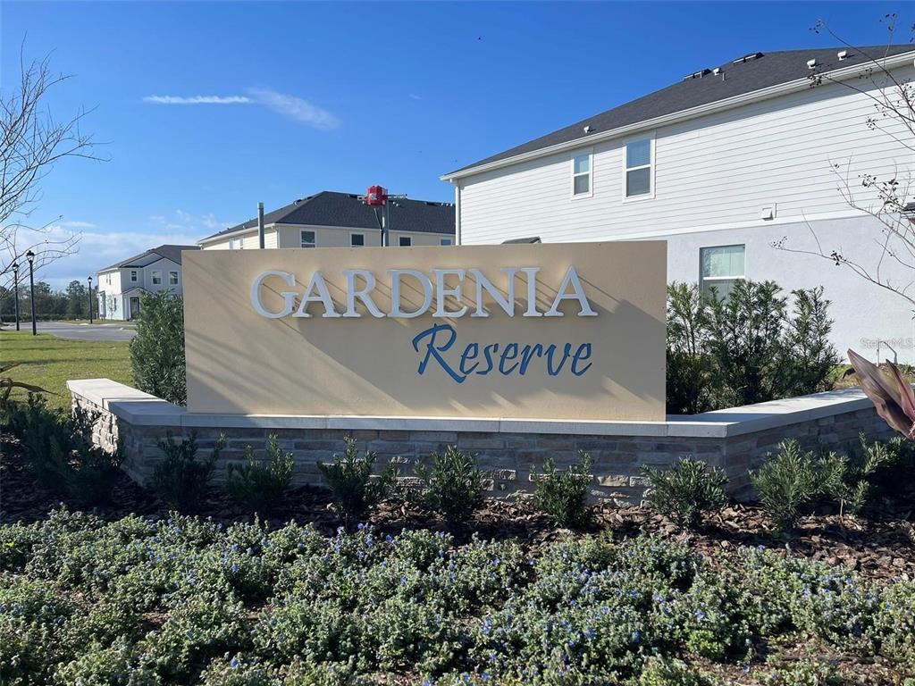 A beige monument sign for Gardenia Reserve stands in front of a residential building — 3107 GARDENIA RESERVE STREET, APOPKA, FL