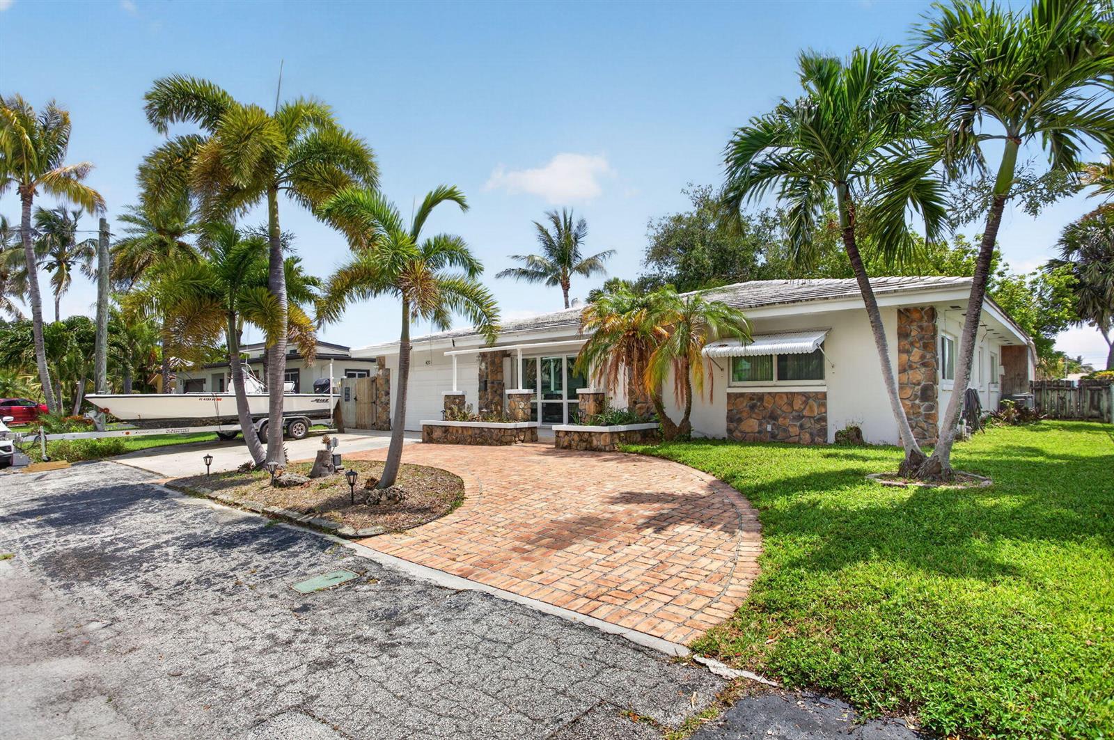 A single-story house with a brick driveway, stone accents, and palm trees in the yard — 420 SE 14th Avenue, Pompano Beach FL 33060, POMPANO BEACH, FL