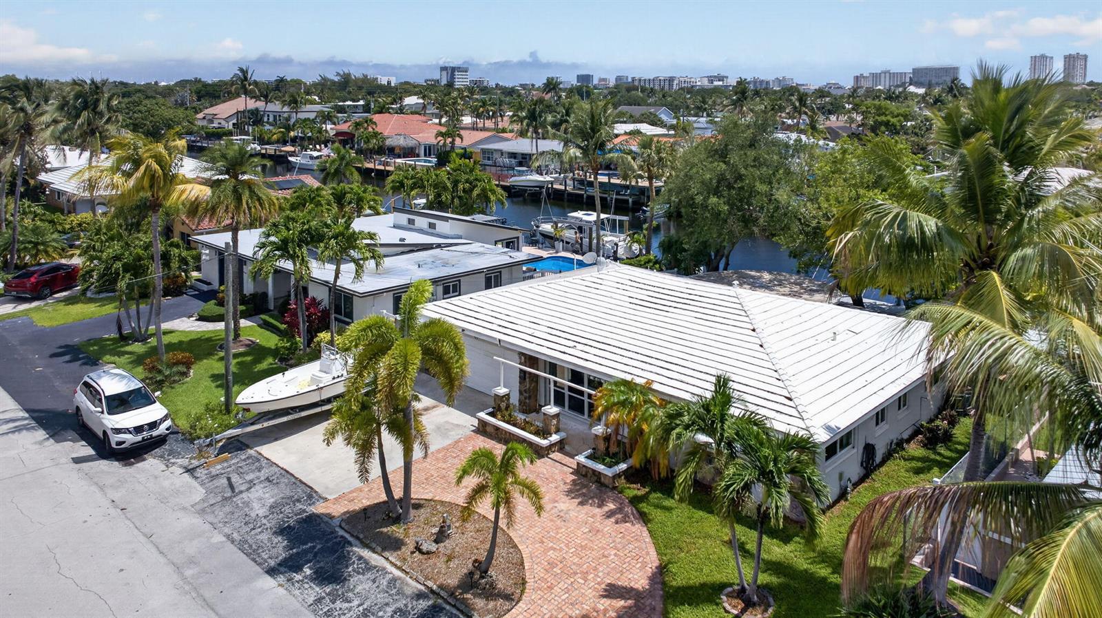 An aerial view of a waterfront house with a white roof, palm trees, and boat — 420 SE 14th Avenue, Pompano Beach FL 33060, POMPANO BEACH, FL