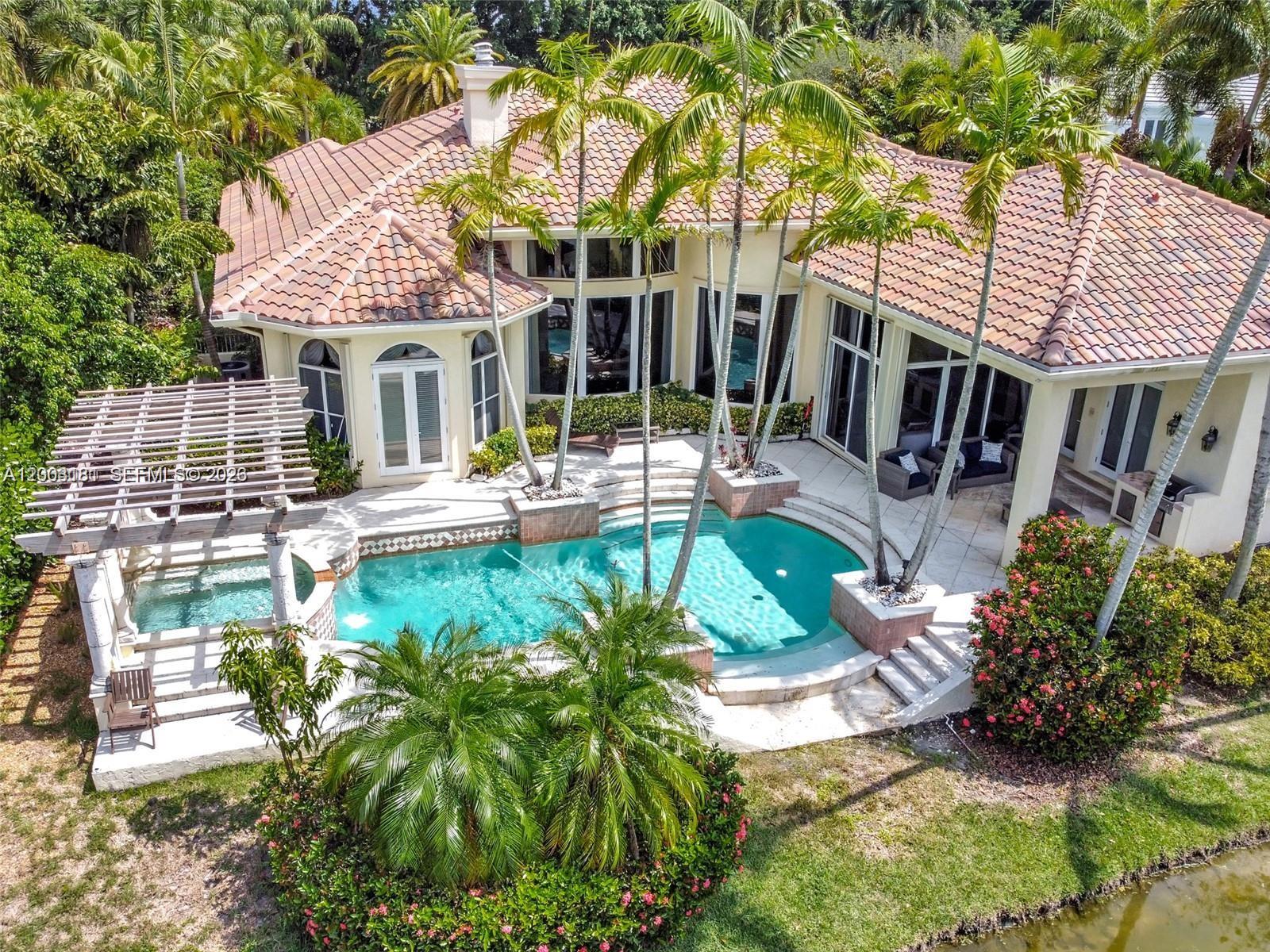 An aerial view of a house with a swimming pool, spa, and palm trees — 10430 Kestrel St, Plantation FL 33324, PLANTATION, FL
