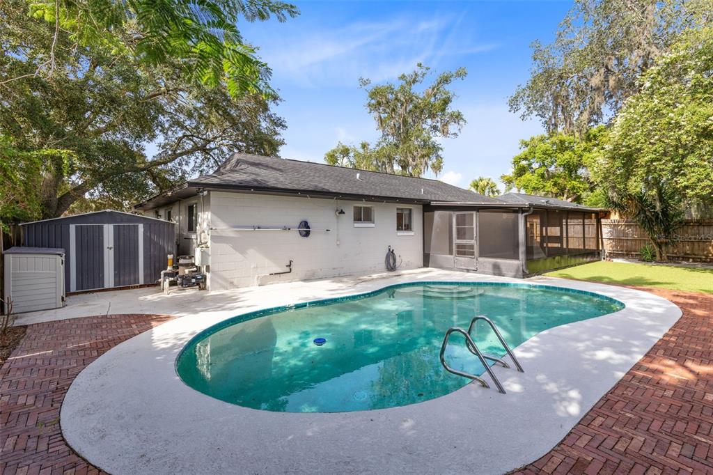 A backyard features a swimming pool, a brick patio, a storage shed, and a screened porch — 611 PHEASANT AVENUE, LONGWOOD, FL